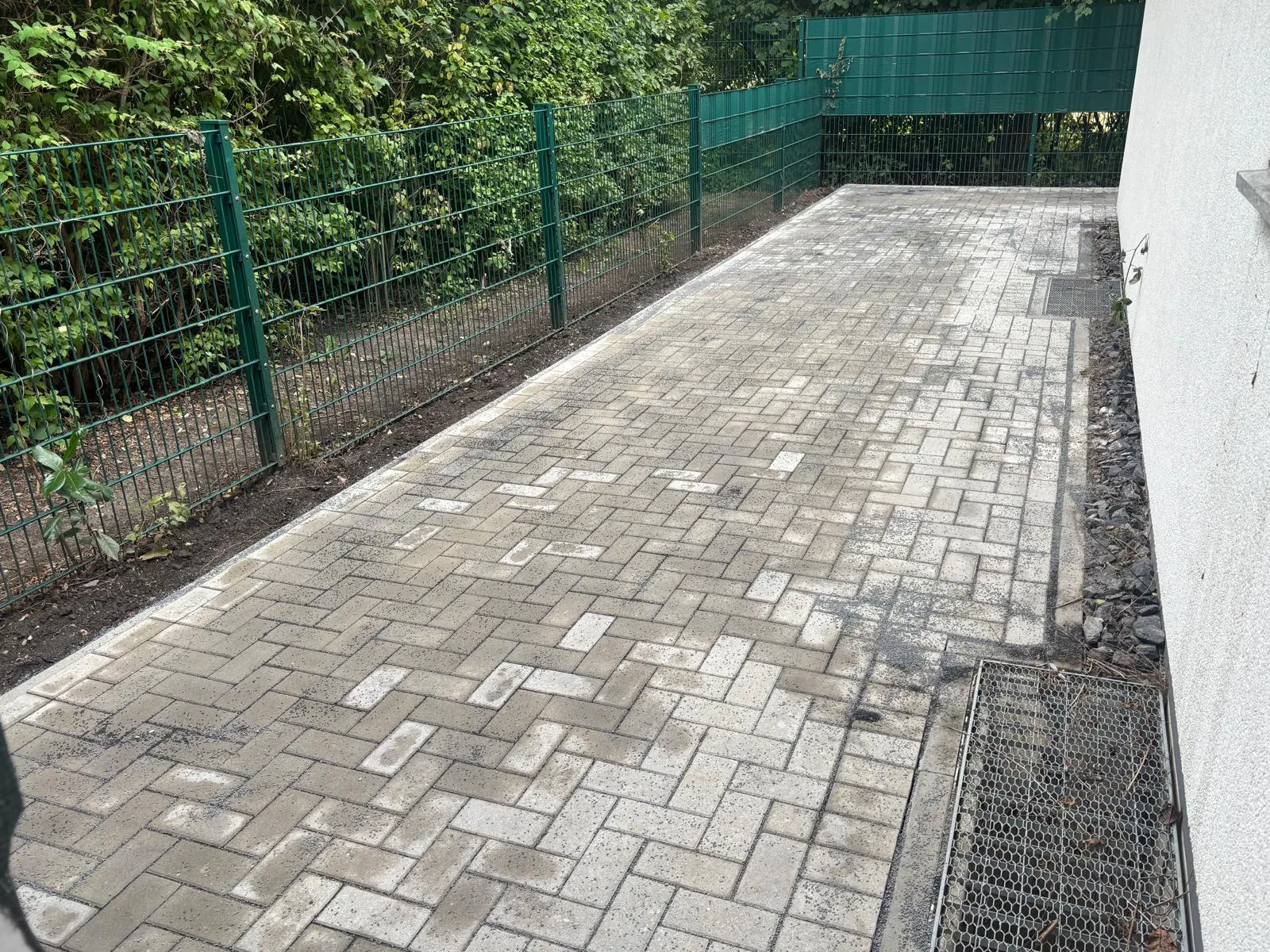 Neu gepflasterte Fläche aus Rechteckpflaster im Läuferverband hinter dem Haus